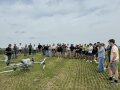 Personen auf einem Feld, die um Drohne stehen